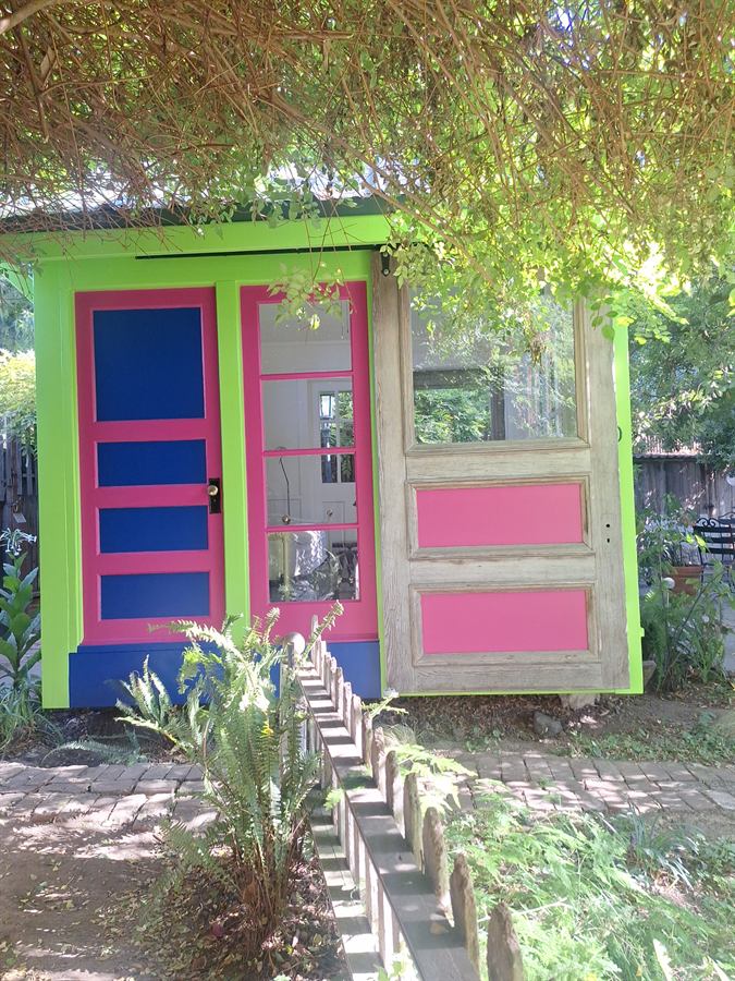 Front of the repainted cottage with blue and magenta doors and a reclaimed timber door